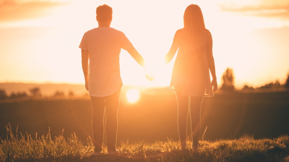 Sunset couple holding hands
