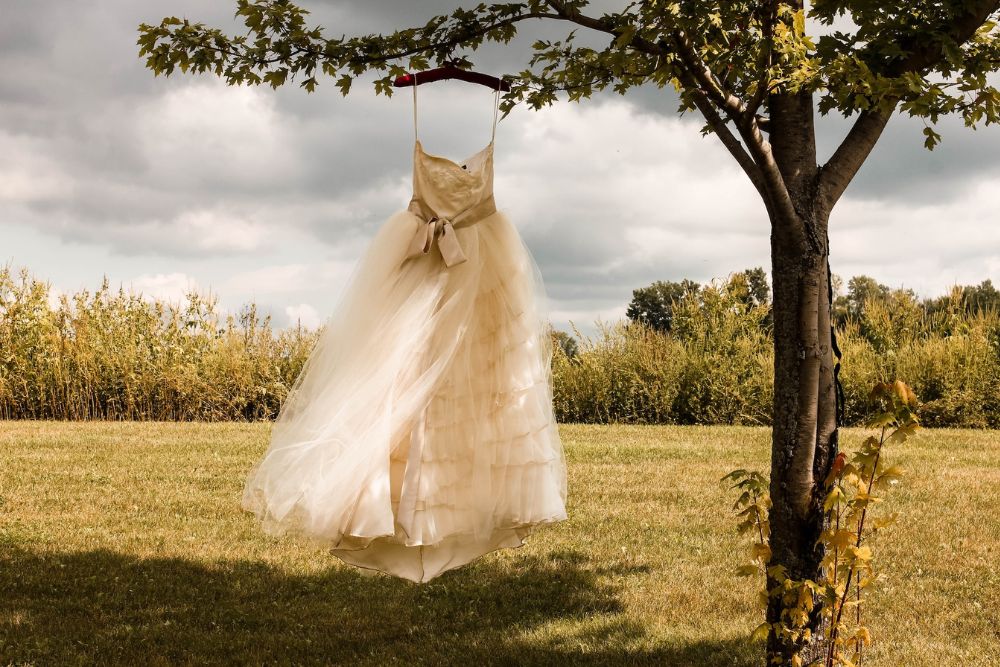 Bridal gown hanging in rural background
