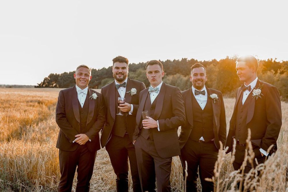 Groomsmen in charcoal suits and green bow ties